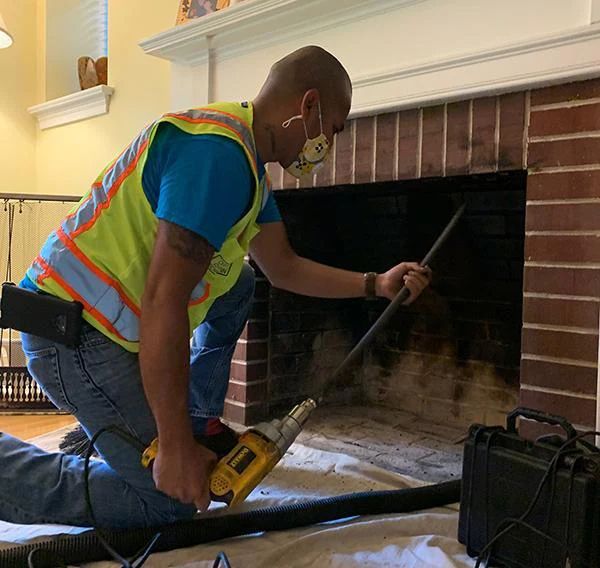a chimney sweep performing a chimney cleaning from inside a home in Delaware County, PA