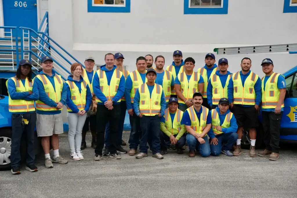 the Chimney Scientists team dressed in safety vests poses in front of the company warehouse, ready to provide chimney services in Glenside, PA