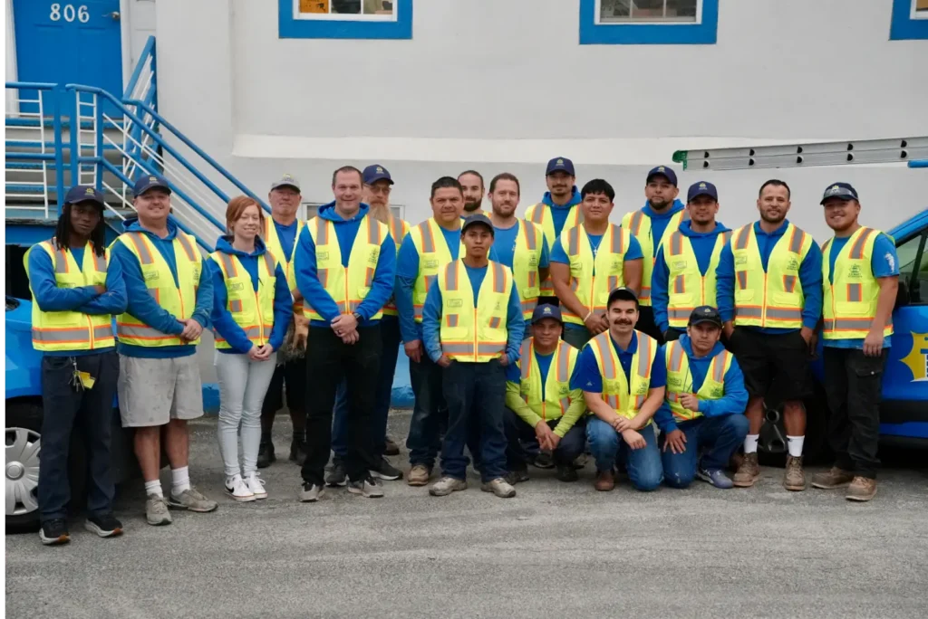 the Chimney Scientists team dressed in safety vests poses in front of the company warehouse, ready to provide chimney services in Philadelphia County, PA
